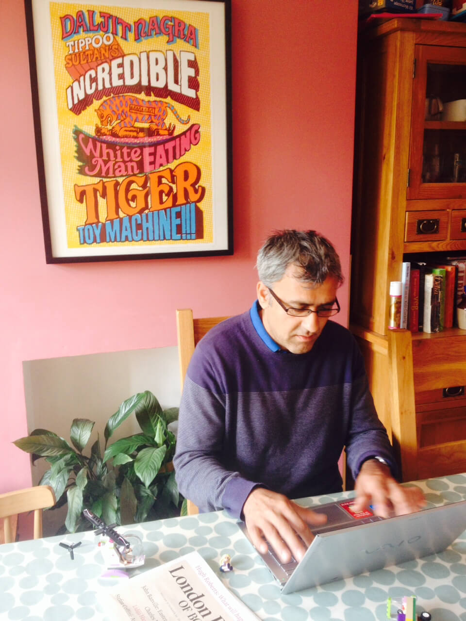 Image shows Poet Dajit Nagra at work at his desk